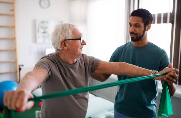 A young physiotherapist exercising with senior patient in a physic room